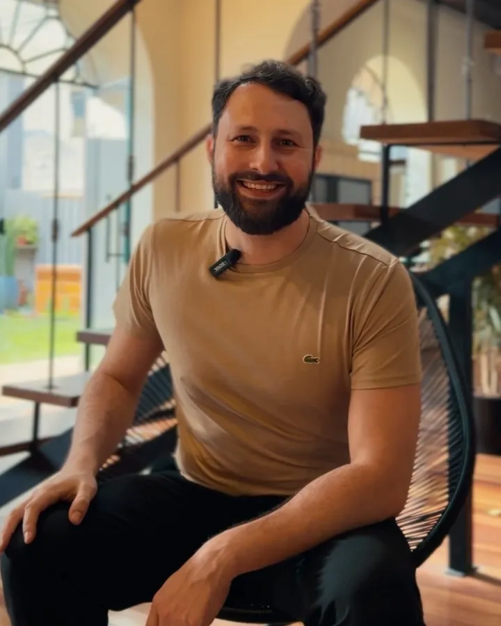 Lucas Medeiros sorrindo, sentado numa cadeira